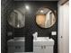 Modern bathroom featuring hexagon tile, glass shower door, and round mirror at 1755 Ingalls St, Lakewood, CO 80214