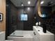 Modern bathroom featuring hexagon tile, glass shower door, and round mirror at 1755 Ingalls St, Lakewood, CO 80214