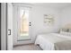 Bedroom featuring all-white decor and a door leading to the outdoor fenced-in yard at 1755 Ingalls St, Lakewood, CO 80214