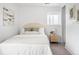 Bright bedroom featuring neutral decor, a woven nightstand, and white bedding for a cozy, modern feel at 1755 Ingalls St, Lakewood, CO 80214