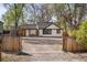 Charming exterior of a white home with black trim, a pergola, and a gravel driveway at 1755 Ingalls St, Lakewood, CO 80214