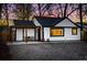 Charming exterior of a white home with black trim, pergola, and a twilight sky at 1755 Ingalls St, Lakewood, CO 80214