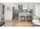 Modern kitchen featuring white cabinets, stainless steel appliances, a stylish backsplash, and breakfast bar seating at 1755 Ingalls St, Lakewood, CO 80214