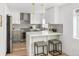 Bright kitchen with stainless steel appliances, white cabinets, gray subway tile backsplash, and breakfast bar at 1755 Ingalls St, Lakewood, CO 80214