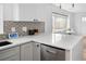 Well-lit kitchen showcasing quartz countertops, stainless steel appliances, and gray cabinetry with ample storage at 1755 Ingalls St, Lakewood, CO 80214