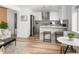Open-concept living space with a modern kitchen featuring white cabinets, stainless steel appliances, and breakfast bar seating at 1755 Ingalls St, Lakewood, CO 80214