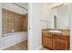 Bathroom with a bathtub with tile surround and wood vanity with granite counter at 277 N Broadway # 409, Denver, CO 80203