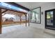 Covered back porch with modern pergola, concrete patio, and a window with privacy curtains at 17161 E Dewberry Dr, Parker, CO 80134