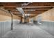 Unfinished basement space with concrete flooring, exposed ductwork, and wood-paneled walls at 17161 E Dewberry Dr, Parker, CO 80134