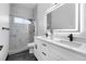 Bathroom features a double vanity, modern faucet fixtures, a large mirror, and a stone shower with glass door at 17161 E Dewberry Dr, Parker, CO 80134