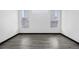 Bright, empty bedroom featuring light gray floors, white walls, and two windows with blinds at 17161 E Dewberry Dr, Parker, CO 80134