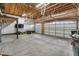 Spacious three-car garage with an open ceiling, a workbench, and ample storage space at 17161 E Dewberry Dr, Parker, CO 80134