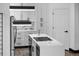 Kitchen island features quartz counters, a cooktop, and stainless steel appliances with white cabinets and black hardware at 17161 E Dewberry Dr, Parker, CO 80134