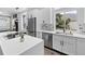 Modern kitchen features stainless steel appliances, white cabinets, quartz counters, and mosaic backsplash tiles at 17161 E Dewberry Dr, Parker, CO 80134