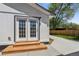 Side view of the home's exterior with a set of glass-paneled doors and a wooden porch at 5202 Reed St, Arvada, CO 80002