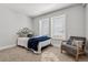 Bedroom featuring neutral carpet and paint, a queen bed, modern chair, and lots of natural light at 5202 Reed St, Arvada, CO 80002