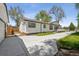 Exterior view with a concrete driveway and manicured lawn, leading to a deck at 5202 Reed St, Arvada, CO 80002