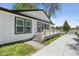 Exterior view of home with white siding, black trim, covered deck, and fresh landscaping at 5202 Reed St, Arvada, CO 80002