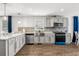Modern kitchen with stainless steel appliances, light gray cabinets and tiled backsplash at 5202 Reed St, Arvada, CO 80002