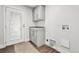 Laundry room with gray cabinets, marble countertops, utility sink, and exterior door at 5202 Reed St, Arvada, CO 80002