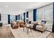 Bright living room with wood floors, tan sofa and blue curtains at 5202 Reed St, Arvada, CO 80002