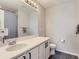 Bright bathroom features a large mirror, white vanity with modern fixtures, and a shower/tub combination at 5995 Fencerow Pl, Brighton, CO 80601