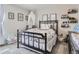 Light-filled bedroom featuring a wrought iron bed frame, unique decor and a cozy, -friendly atmosphere at 5995 Fencerow Pl, Brighton, CO 80601