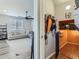 Hallway with a glimpse of a living room, a coat rack, and an area with an orange accent wall at 5995 Fencerow Pl, Brighton, CO 80601