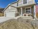 Charming two-story home featuring a three-car garage and inviting front porch with nice decorations at 5995 Fencerow Pl, Brighton, CO 80601