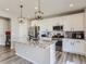 Modern kitchen featuring white cabinets, stainless steel appliances, and a granite island with pendant lighting at 5995 Fencerow Pl, Brighton, CO 80601