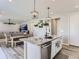 Open kitchen and dining area with an island, granite countertops, modern lighting, and stainless steel appliances at 5995 Fencerow Pl, Brighton, CO 80601