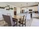 Open kitchen and dining area featuring white cabinets, an island, and stainless steel appliances at 5995 Fencerow Pl, Brighton, CO 80601