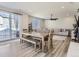 Bright dining and living area with hardwood floors and sliding glass doors to the backyard patio at 5995 Fencerow Pl, Brighton, CO 80601