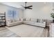 Spacious living room features a ceiling fan, a large sectional sofa and a light-colored rug at 5995 Fencerow Pl, Brighton, CO 80601