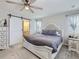 Bright main bedroom with a decorative ceiling fan, soft carpet, and a sliding barn door to the ensuite at 5995 Fencerow Pl, Brighton, CO 80601