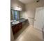Bathroom features double sinks with brown cabinets, tile floors, granite countertops, and a large mirror at 17346 Nature Walk Trail Trl # 201, Parker, CO 80134