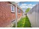 View of the brick exterior with an open backyard area, partially fenced-in for privacy at 6086 W Arizona Ave, Lakewood, CO 80232
