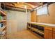 Unfinished basement area featuring pegboard, workbench, and wood floors at 6086 W Arizona Ave, Lakewood, CO 80232