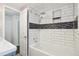 Updated bathroom features white subway tile shower/tub combo with a decorative accent stripe and modern fixtures at 6086 W Arizona Ave, Lakewood, CO 80232