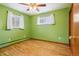 Bright bedroom featuring hardwood floors, a ceiling fan, and natural light from the windows at 6086 W Arizona Ave, Lakewood, CO 80232