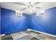 Blue bedroom with ceiling fan, two windows and unique carpet tiles is a finished space in the basement at 6086 W Arizona Ave, Lakewood, CO 80232