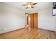 Bright bedroom with wood floors, ceiling fan and closet with natural wood doors provides ample storage space at 6086 W Arizona Ave, Lakewood, CO 80232
