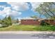 Exterior image of a brick home with a well-manicured lawn and a trimmed hedge at 6086 W Arizona Ave, Lakewood, CO 80232