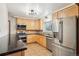 Functional kitchen features stainless steel appliances, warm wood cabinetry, and durable granite countertops at 6086 W Arizona Ave, Lakewood, CO 80232