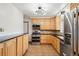 Functional kitchen features stainless steel appliances, warm wood cabinetry, and durable granite countertops at 6086 W Arizona Ave, Lakewood, CO 80232