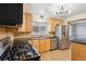 Functional kitchen features stainless steel appliances, warm wood cabinetry, and durable granite countertops at 6086 W Arizona Ave, Lakewood, CO 80232
