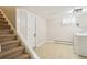 Finished basement room with laundry area featuring tile floors, white walls, and stairs to the upper level at 6086 W Arizona Ave, Lakewood, CO 80232
