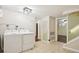 Basement laundry room featuring tile floors, white washer and dryer, and access to other rooms at 6086 W Arizona Ave, Lakewood, CO 80232