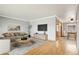 Bright living room with hardwood floors, neutral walls, and modern decor, seamlessly flowing into the dining area at 6086 W Arizona Ave, Lakewood, CO 80232
