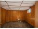 Unfinished basement area with wood paneling and a small window providing natural light at 15930 E Ford Pl, Aurora, CO 80017